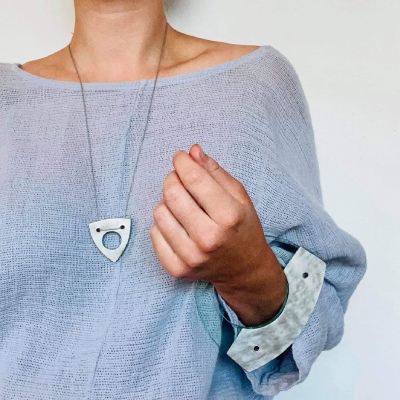 Model wearing blue with pewter and clear pendant and bangle