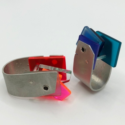 2 stacked Hebbe rings, one with blue inserts the other with clesr and pink/ red inserts