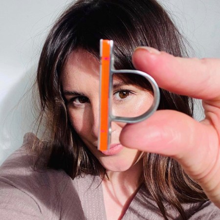 Brunette model peeping through an orange Hebbe ring